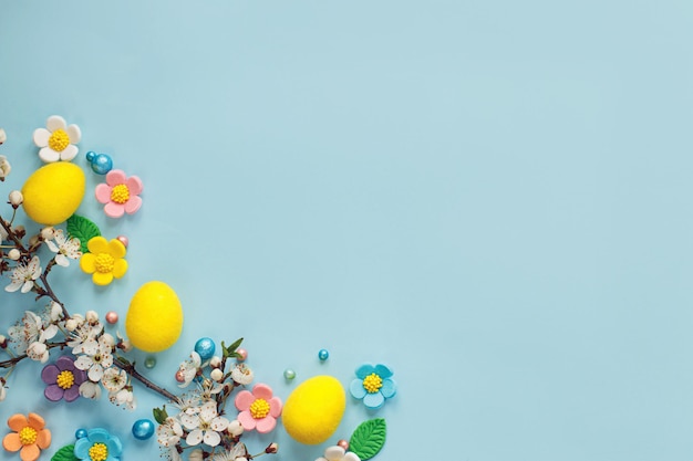 Vrolijk Pasen Pasen eieren snoep bloemen en bloeiende kersentak plat lag op blauwe achtergrond Stijlvolle pasen sjabloon met ruimte voor tekst Wenskaart of spandoek