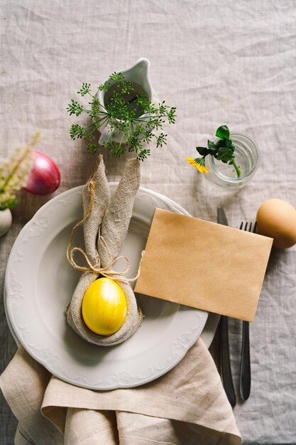 Vrolijk Pasen Stijlvolle paaseieren op een servet met lentebloemen op witte houten achtergrond Tabel instelling Het concept van een vrolijke paasvakantie