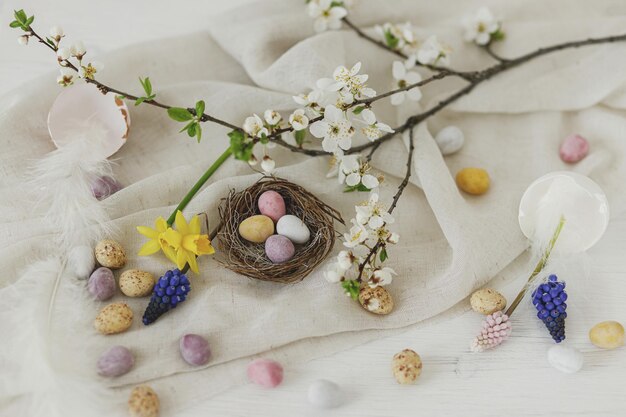 Vrolijk Pasen stijlvolle Pasen chocolade eieren in nest lente bloemen veren en linnen doek