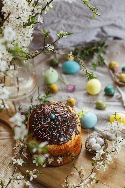 Vrolijk pasen zelfgemaakt paasbrood en natuurlijk geverfde paaseieren met lentebloemen op linnen servet op rustieke tafel traditioneel paasvoedsel bovenaanzicht