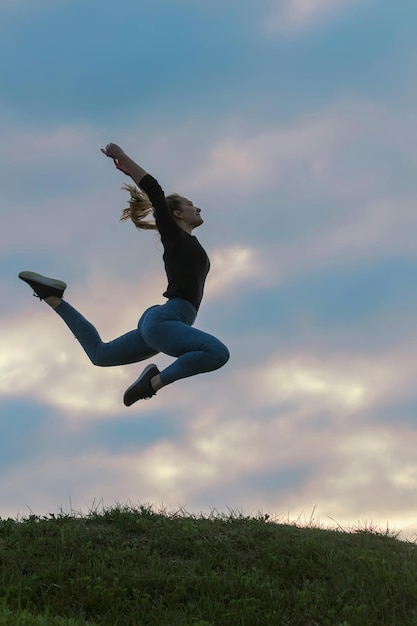 Vrolijk positief meisje springt in de lucht buiten ochtendwolken