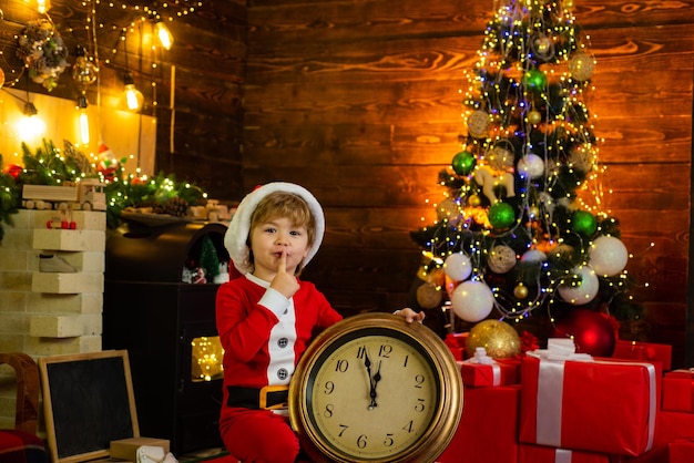 Vrolijk Santa Elf kind met klok Controleer de inhoud van de kerstsok Kerstcadeaus Gezinsvakantie
