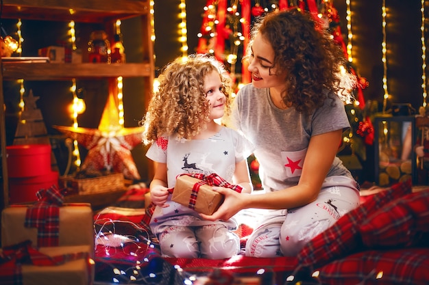 Vrolijk schattig krullend meisje en haar oudere zus die geschenken uitwisselen