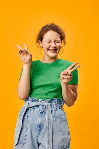 Vrolijk schattig meisje met oorbellen groene t-shirts gele achtergrond