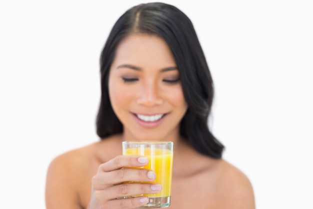 Vrolijk sensueel naaktmodel het drinken jus d&#39;orange