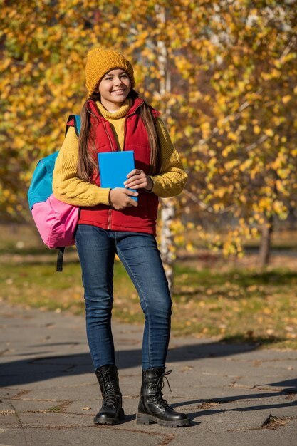 vrolijk tienermeisje terug naar school in de herfst volledige lengte