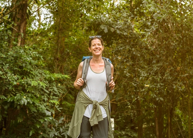 Vrolijk wijfje backpacker in het bos