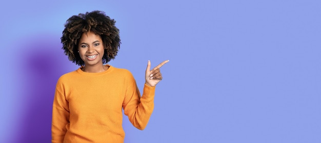 Foto vrolijke aantrekkelijke afrikaanse vrouw die lege ruimte toont