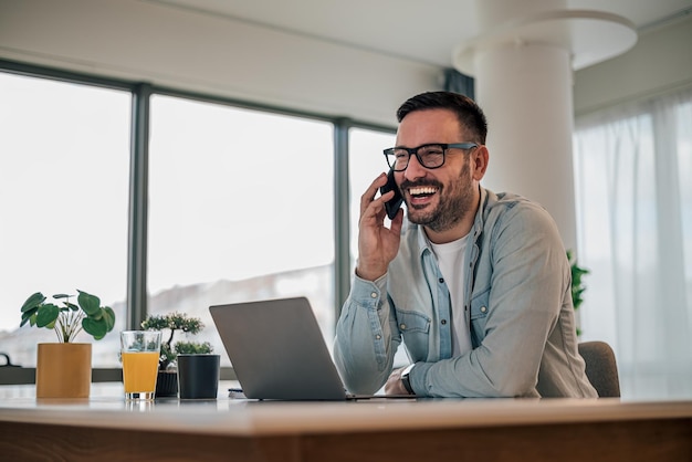 Vrolijke afgeleid zakelijke professional praten op mobiele telefoon op kantoor