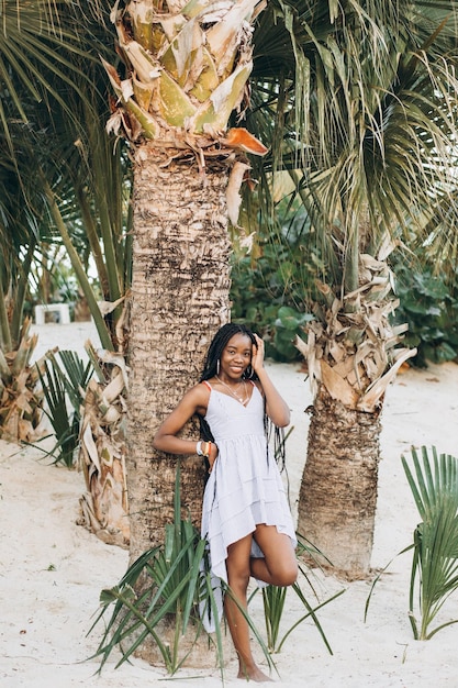 vrolijke Afro-Amerikaanse jonge vrouw die plezier heeft op het strand bij zonsondergang