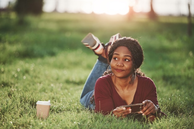 Vrolijke Afro-Amerikaanse vrouw in het park in de zomer