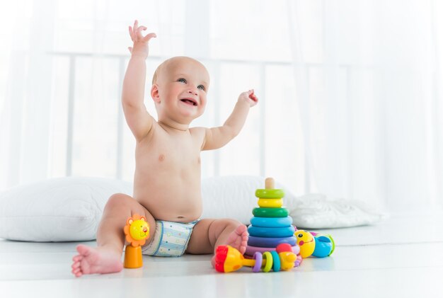 Vrolijke baby in een luier lacht en speelt