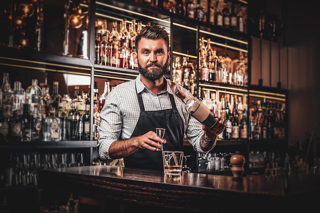 Vrolijke barman maakt drank voor klanten bij gezellig restaurant.