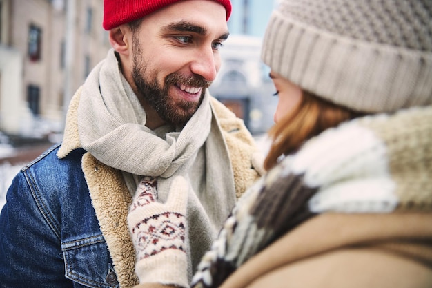 Vrolijke bebaarde man dateert met vrouw buitenshuis in de winter