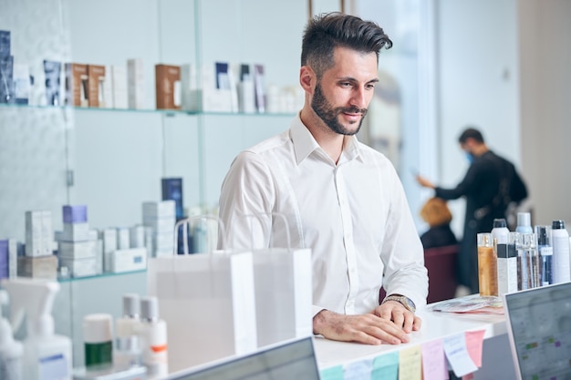 Vrolijke bebaarde man die schoonheidssalon bezoekt en geluk uitdrukt na perfecte service perfect