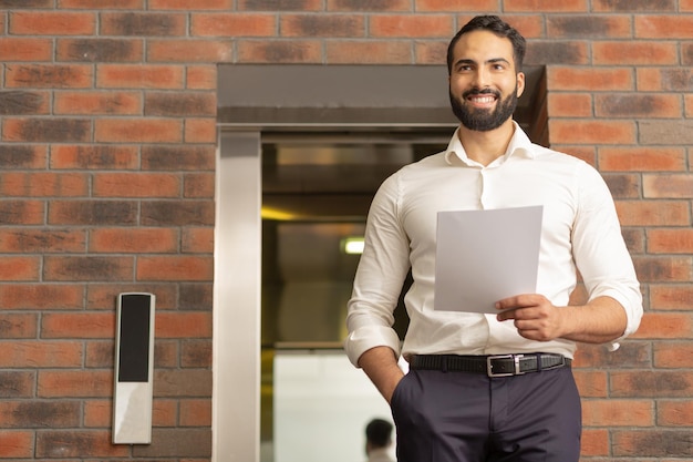 Vrolijke bebaarde man op zoek naar zijn collega's