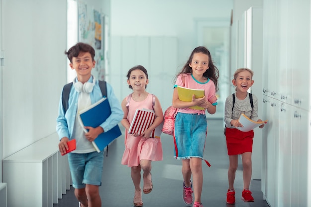 Vrolijke blije kinderen voelen zich gelukkig na het beëindigen van de schooldag