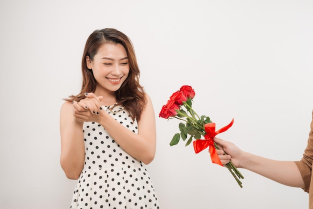 Vrolijke charmante jonge vrouw bos bloemen ontvangen van haar vriendje op witte achtergrond