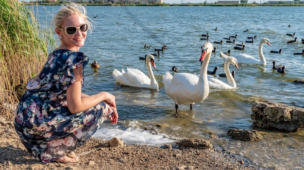 Vrolijke dame in een mooie jurk jonge glimlacht naar de camera op de achtergrond van vogels