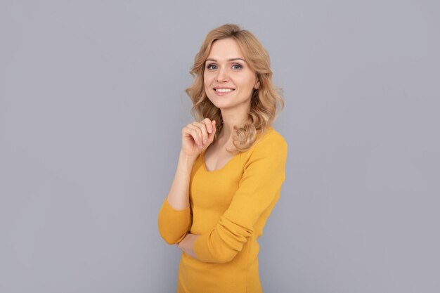 Vrolijke dame met krullend haar poseren mode en schoonheid vrouwelijke mannequin mooie blik van jonge lachende meisje blonde vrouw blonde vrouw portret uitdrukken positieve emoties glad gezicht huid