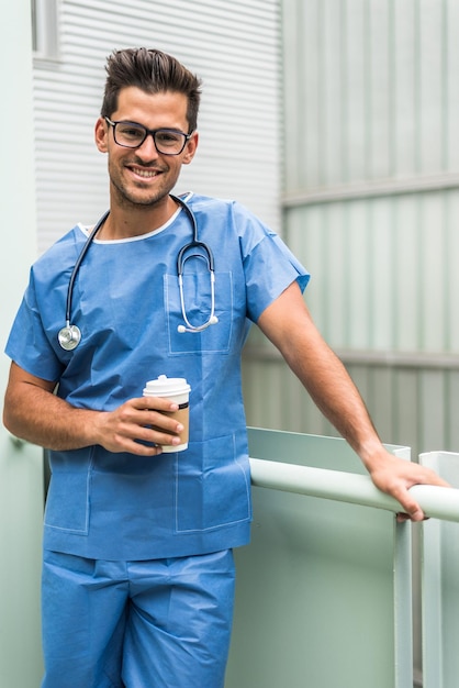 Vrolijke dokter die koffie drinkt in het ziekenhuis