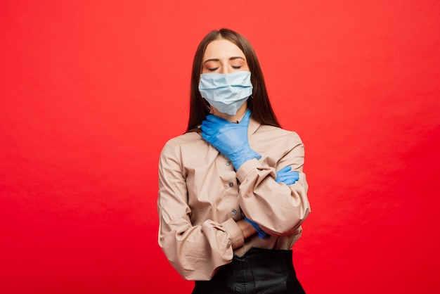 Vrolijke en vrolijke jonge vrouw spelen met beschermende medische masker en blauwe handschoenen