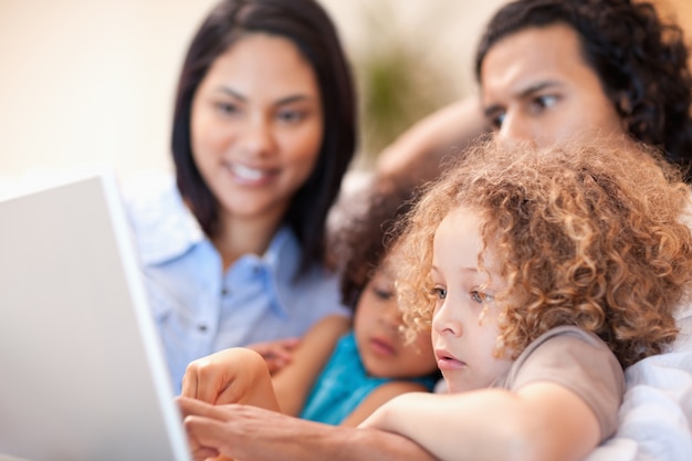 Vrolijke familie die laptop samen met behulp van