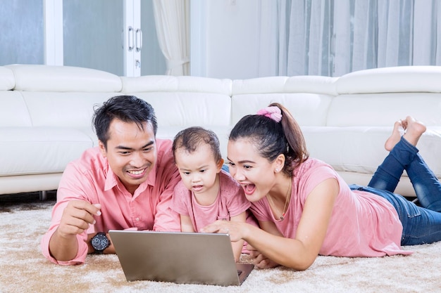 Vrolijke familie samen spelen met laptop