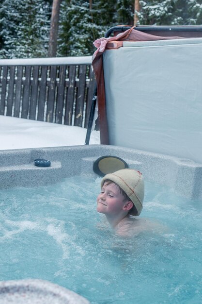 Vrolijke gelukkige familie met kinderen geniet van een warm bad in de jacuzzi whirlpool op koude winterdag