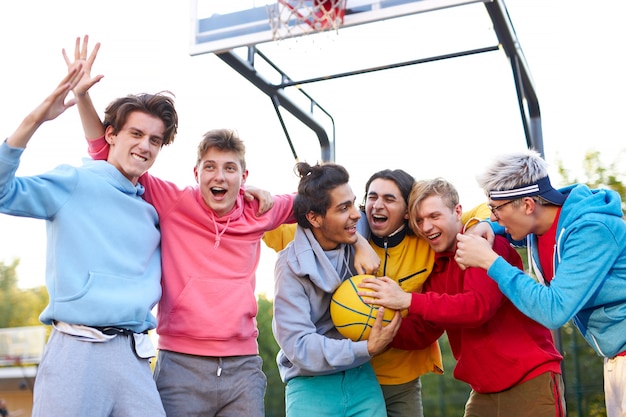 Vrolijke, gelukkige groep jonge jongens vieren hun winnende, blanke jongens die elkaar feliciteren