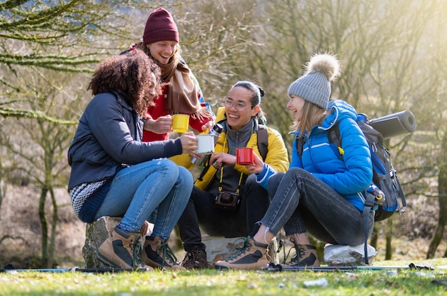 Vrolijke groep jonge wandelaars ontbijten op de berg Survival en avontuur concept