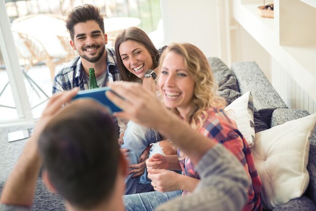 Vrolijke groep vrienden die thuis plezier hebben, vereniging spelen.