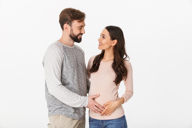 Vrolijke jonge man die met zijn zwangere vrouw