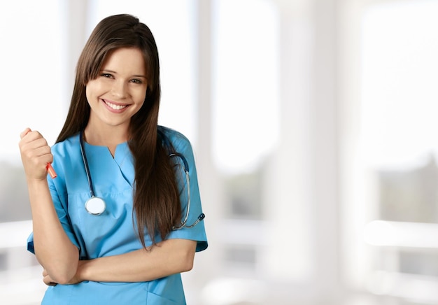 Vrolijke jonge verpleegster in blauwe scrubs