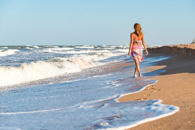 Vrolijke jonge vrouw geniet van stormachtige golven op zee