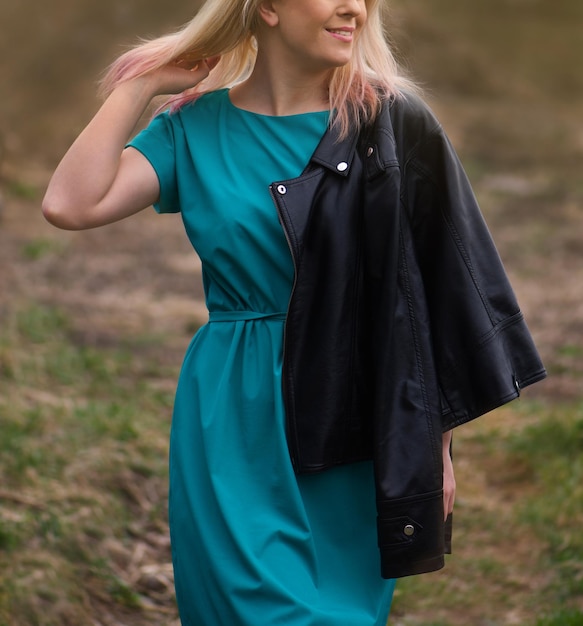 Vrolijke jonge vrouw met lang haar poseren in de straat op zonsonderganglichten jonge openhartige vrouw op zonnige dag buitenshuis emotionele vrouw die plezier heeft buitenshuis