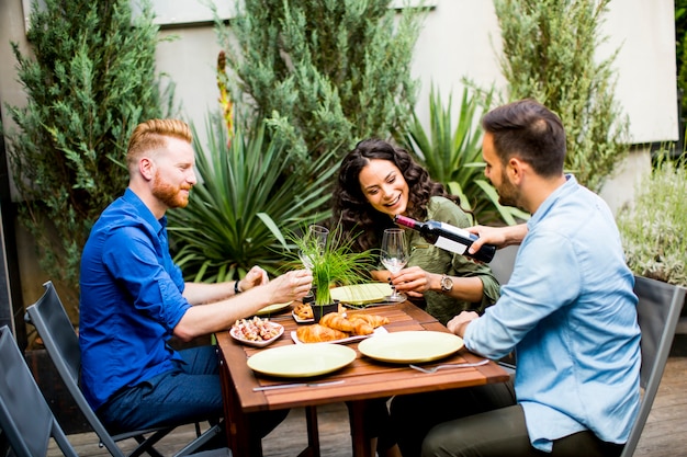 Vrolijke jongeren lunchen op de binnenplaats en hebben plezier