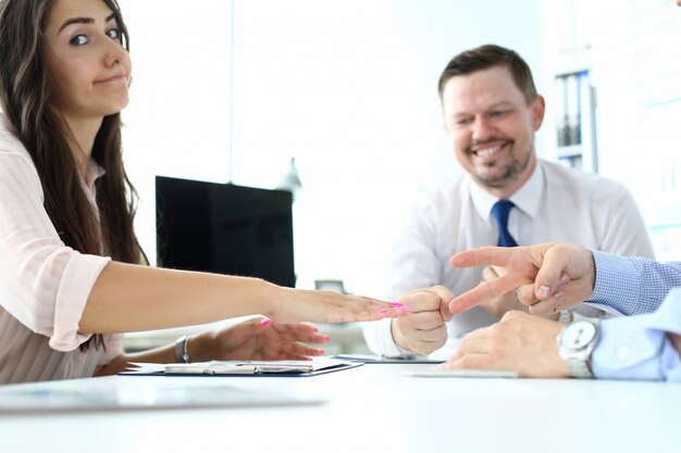 Vrolijke kantoormedewerkers spelen rock-paper-scissors spel