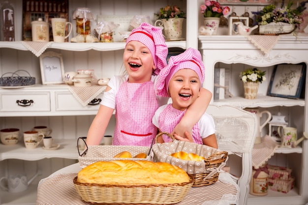 Vrolijke kinderen lachen in de keuken bij de tafel met bakken