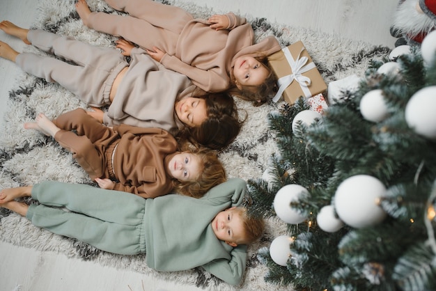 Vrolijke kinderen met cadeautjes naast de kerstboom