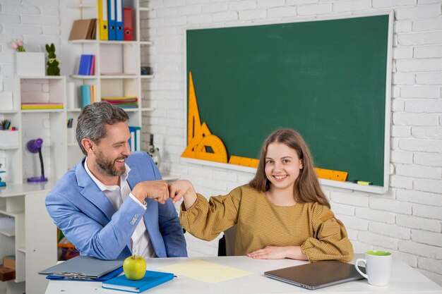 Vrolijke kindstudie in de klas met tutor vuist tot vuist