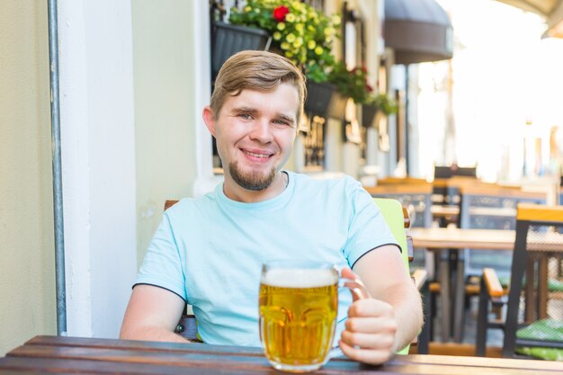 Vrolijke lachende man met een grote bierpul buiten