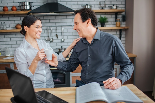 Vrolijke man en vrouw zijn samen in de keuken.