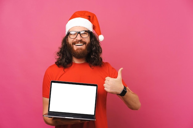 Vrolijke man houdt van dit aanbod met duim omhoog terwijl hij een laptopscherm laat zien