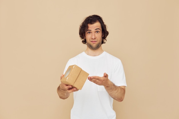 Vrolijke man in een wit t-shirt met een geschenkdoos