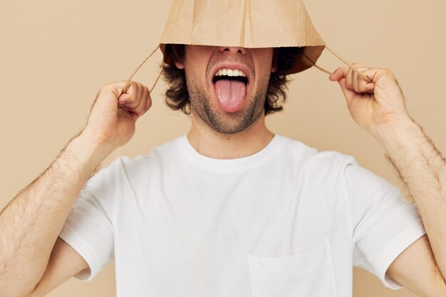 Vrolijke man in een wit T-shirt met papieren zak beige achtergrond