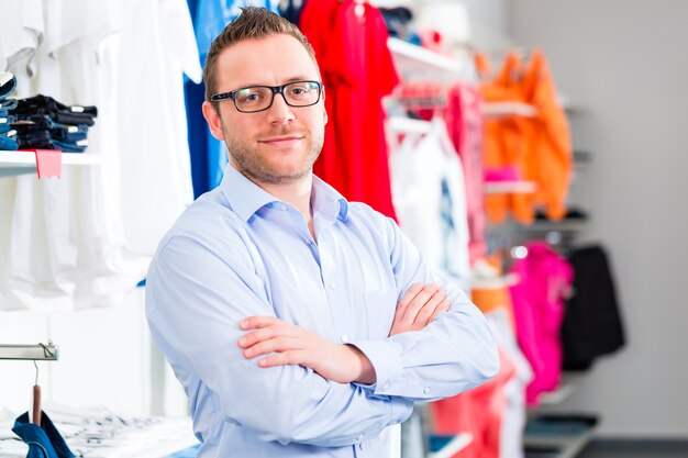 Foto vrolijke man kleren in winkel of winkel kopen