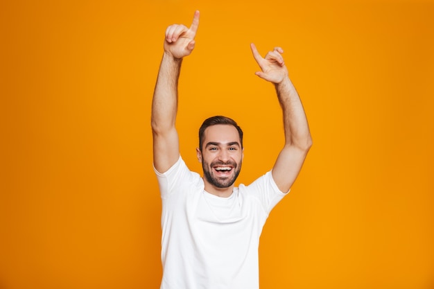 vrolijke man met baard en snor lachend staand, geïsoleerd op geel