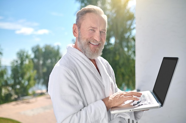 Vrolijke man met de laptop vooruitkijkend