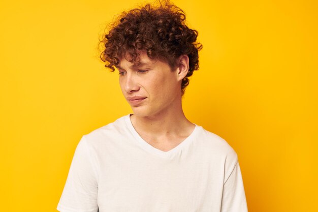 Vrolijke man met krullend haar in een witte t-shirt jeugdstijl